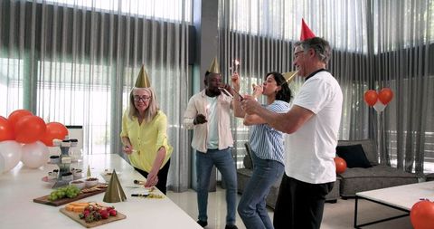 Diverse colleagues enjoying office celebration with decor and snacks