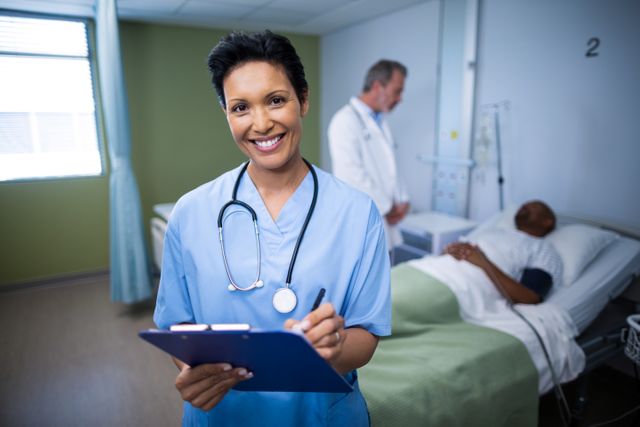 This image depicts a smiling female nurse writing on a clipboard in a hospital ward. A patient is lying in a bed in the background, with a doctor standing nearby. This image can be used for healthcare-related content, medical websites, hospital brochures, and articles about patient care and nursing.