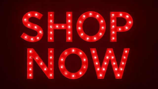 Glowing shop now marquee sign casting red halo lights with round bulbs retro display