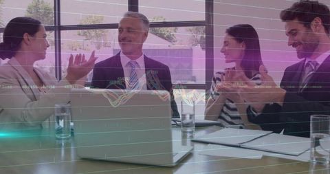 Team Celebrating Success in Modern Office Setting with Laptops and Graphics