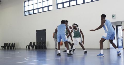 Energetic Male Basketball Players Competing on Indoor Court
