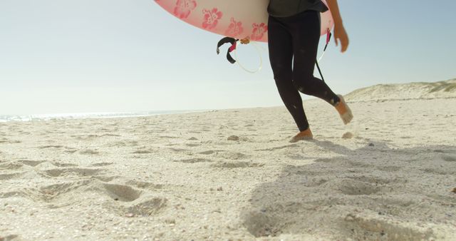Surfer walks on the beach, with copy space. Outdoor scene captures the anticipation of a surfing session.