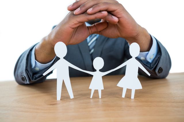 Businessman protecting paper cut out family with hands - Download Free Stock Photos Pikwizard.com