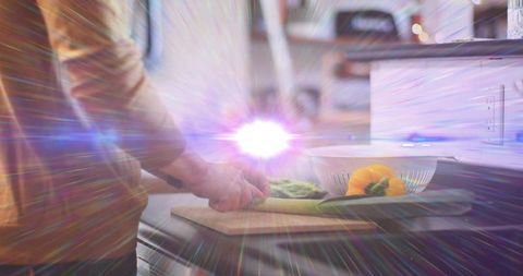 Home cook chopping fresh vegetables on cutting board, slicing leek and bell pepper