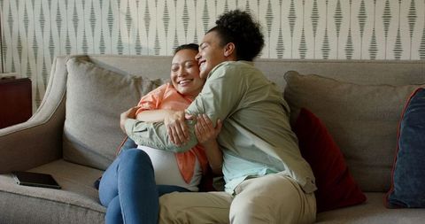 Happy Couple Embracing on Sofa Enjoying Quality Time