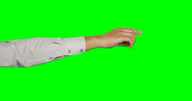A Caucasian person's arm is extended in a fist against a green screen background, with copy space. Ideal for compositing, the green screen allows for easy background replacement in visual effects work.