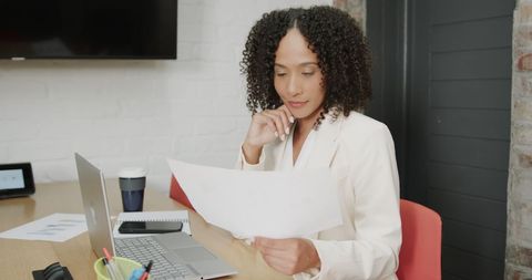 Focused Businesswoman Analyzing Documents in Contemporary Office