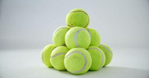 Pyramid of Vibrant Tennis Balls on White Background
