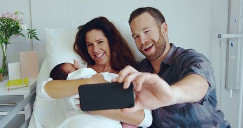 Happy Parents Celebrating Newborn Arrival with a Selfie
