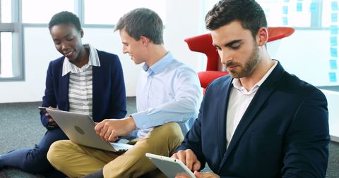 Diverse Young Professionals Collaborating with Technology in Modern Office