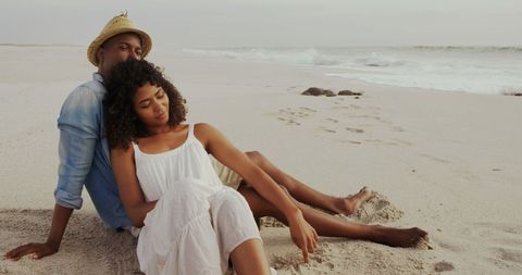 Relaxed Couple Enjoying Peaceful Moments on Beach at Sunset