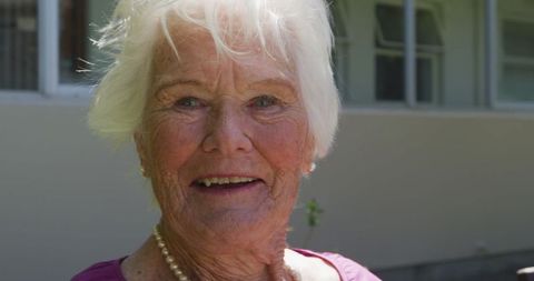 Happy Senior Woman Enjoying Outdoor Time in Retirement Home