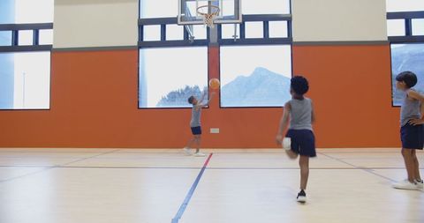 Teen Boys Playing Basketball in Gym