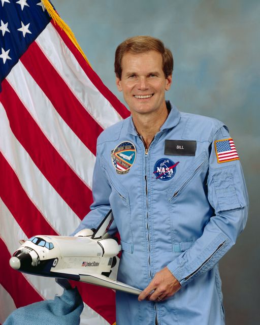 Astronaut in Flight Suit Holding Shuttle Model with American Flag - Download Free Stock Images Pikwizard.com