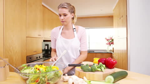Woman Preparing Fresh Salad with Colorful Peppers in Modern Kitchen