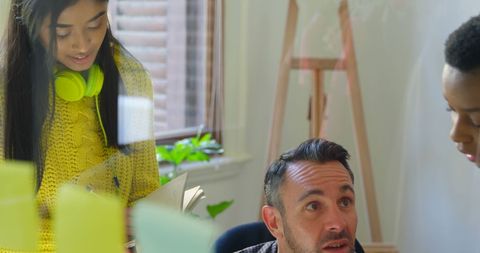 Diverse team collaborating in modern office on creative project