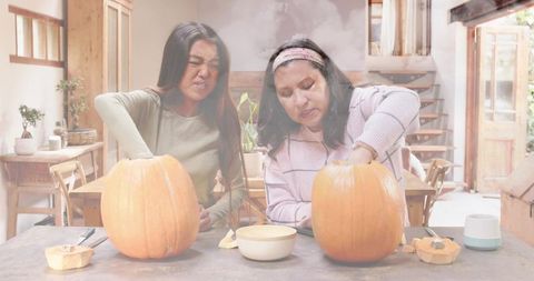 Carving Pumpkins Together in Cozy Rustic Kitchen, Friends Scooping and Crafting