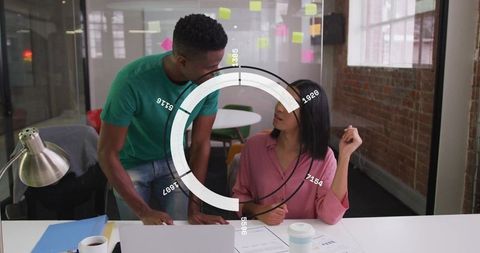 Young Professionals Collaborating in Modern Office with Data Visualization