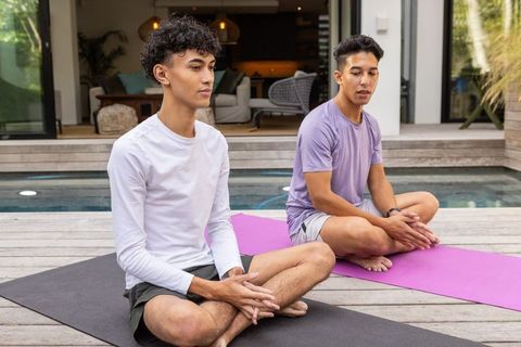 Friends Practicing Outdoor Meditation on Wooden Deck