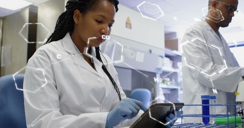 Scientist analyzing data on tablet in modern laboratory