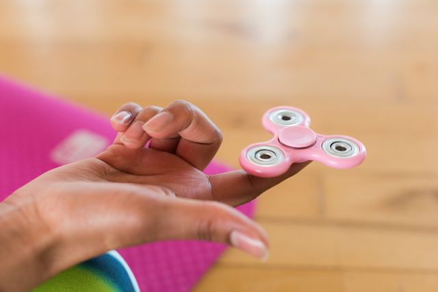 Girl holding a fidget spinner in a fitness room