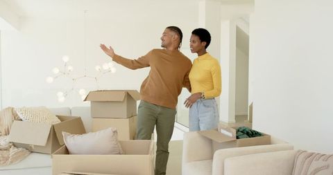 Happy Couple Unpacking Boxes in Stylish Minimalist Home