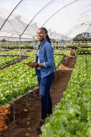 Eco-Friendly Modern Agriculture in Greenhouse with Smiling Woman