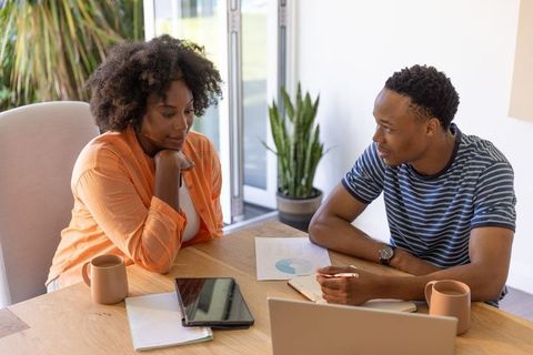 African american colleagues planning home office project with laptop and analytics chart