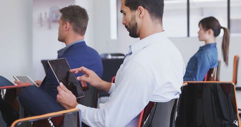 Colleagues using tablets during office meeting