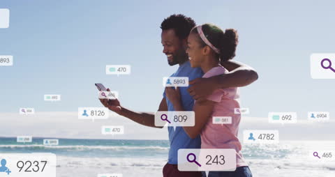 Couple on Beach Engaging with Social Media