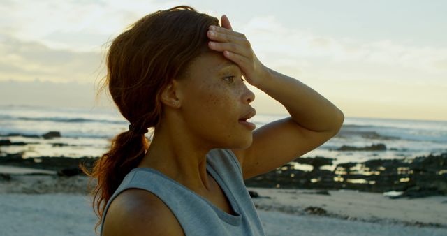 Woman cooling down at the beach after jogging. Useful for promoting fitness routines, healthy lifestyles, beach activities, wellness programs, and outdoor exercises.