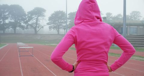 Female Athlete in Pink Hoodie Focused on Hurdles - Download Free Stock Images Pikwizard.com