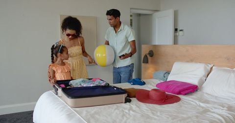 Family Enjoying Vacation Preparations with Luggage in Hotel Room
