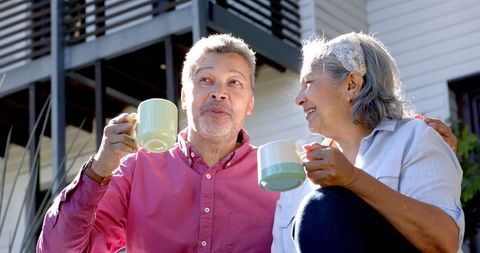 Happy Seniors Enjoying Tea Outdoors Together in Sunlight