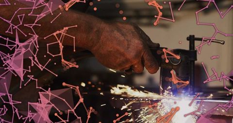 Worker grinding metal with grinder producing sparks in industrial workshop with pink overlay