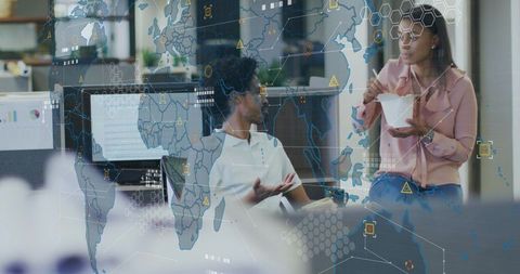 Colleagues collaborating over data visualization overlay while eating lunch in office