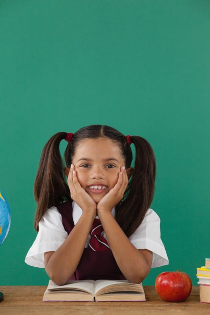 Smiling Schoolgirl Reading Book in Classroom - Download Free Stock Photos Pikwizard.com