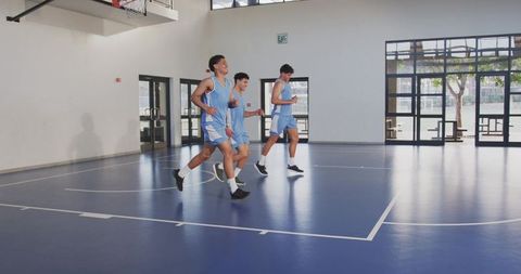 Male Athletes Jogging Together on Indoor Basketball Court