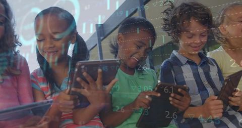 Smiling children using tablets with digital analytics overlay for STEM learning and collaboration