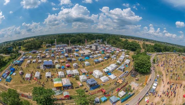 Aerial panorama capturing summer festival with vendor tents, stages, food trucks, crowds