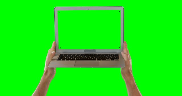 Ideal for digital projects that need customizable content, this image features a laptop held in two hands with a green screen for easy editing. It can be utilized in marketing, presentations, instructional design, and creative media to insert custom videos, images, or interactive elements.