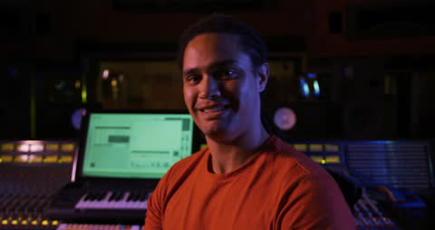 Smiling Sound Engineer in Dark Recording Studio