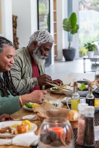 African american couple enjoying relaxed meal at modern open-plan dining table home