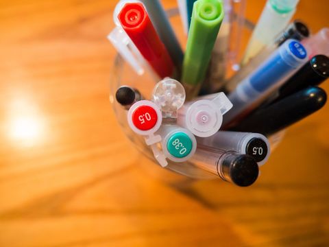 Colorful Variety of Pens and Markers in Glass Holder