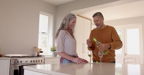 Senior Couple Enjoying Wine in Modern Kitchen Setting - Download Free Stock Images Pikwizard.com