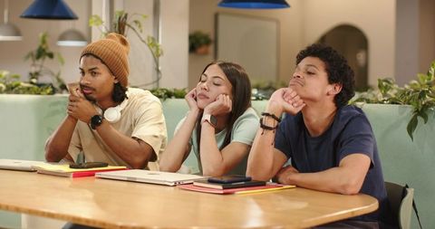 Young african american friends leaning on table in coworking lounge, looking contemplative