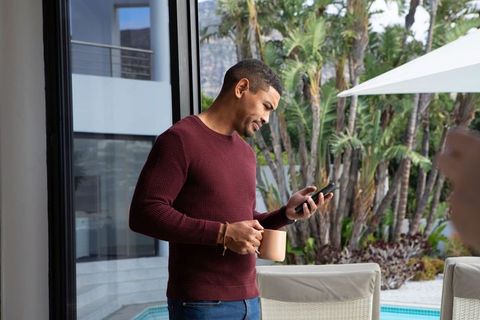 Man Relaxing on Poolside Terrace with Smartphone and Coffee Key Keywords