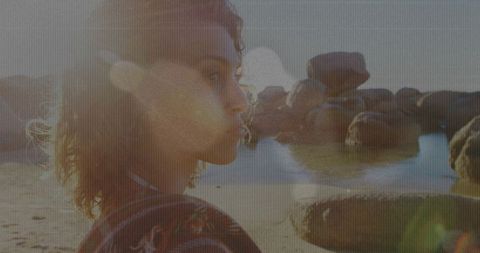 Woman gazing at sunset beach with tranquil waters