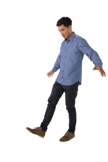 Young man in casual attire balancing while looking at his shoe. Ideal for concepts related to focus, balance, casual fashion, and isolated subjects. Useful for advertisements, lifestyle blogs, and educational materials.