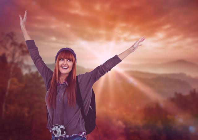 Digital composite of mountain travel, happy woman with hands up in front of the sunset